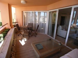 Habitación con bañera y balcón con mesa. en Apartamento Puerto de Sotogrande con vistas al mar, en Sotogrande
