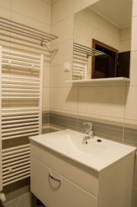 a white bathroom with a sink and a mirror at Industrial Belišće in Belišće +36 photos