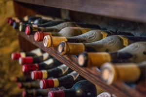 Un montón de botellas de vino están alineadas en un estante en Al Paschè, en Dronero