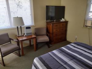 Schlafzimmer mit einem Bett, einem TV und einer Kommode in der Unterkunft Yosemite Gatekeeper's Lodge in El Portal