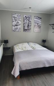 um quarto com uma cama com quatro fotografias na parede em Lækjarbakki 11 em Varmahlid