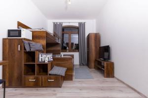 a living room with wooden furniture and a tv at Apartment House Kamzík 9 in Donovaly