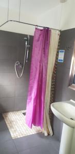 e bagno con doccia con tenda viola. di Bennetts Hotel a Long Eaton