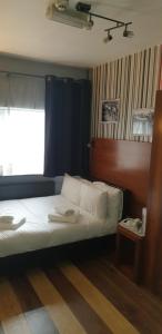 sypialnia z łóżkiem i oknem w pokoju w obiekcie Bennetts Hotel w mieście Long Eaton
