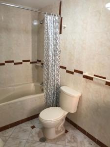 a bathroom with a toilet and a bath tub at Hospedaje La Florida in Urubamba