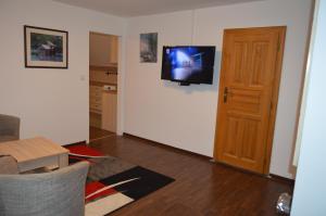 a living room with a tv on the wall and a door at Bohemica Apartman 4 in Kouřim