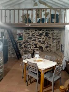 uma mesa e cadeiras num quarto com uma parede de pedra em La lammia di Pisticci em Pisticci
