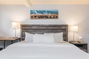 a bedroom with a large white bed with two lamps at Miller Park Lodge in Jackson