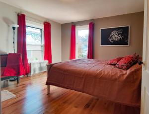 a bedroom with a large bed with red curtains at Historic Oak Park Home for 6 / Hemingway District in Oak Park