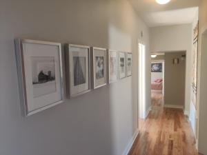 a hallway with a bunch of pictures on a wall at Historic Oak Park Home for 6 / Hemingway District in Oak Park