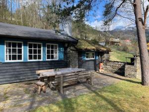 un tavolo da picnic in legno di fronte a una casa di Voss/Bolstad: Peaceful countryside cabin/lodge a Bolstadøyri
