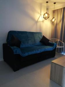 Sofá azul en la sala de estar con mesa en Hotel Malibu Park, en Adeje
