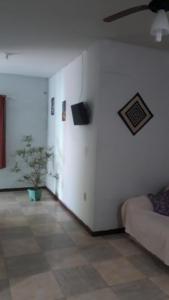 a living room with a couch and a tv at Casa Verde in Tamoios