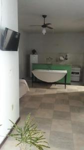 ein Wohnzimmer mit einer weißen Badewanne und einem grünen Tisch in der Unterkunft Casa Verde in Tamoios