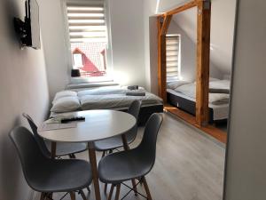 Cette chambre comprend une table, des chaises et un lit. dans l'établissement Apartament przy Parku Zdrojowym, à Kudowa-Zdrój