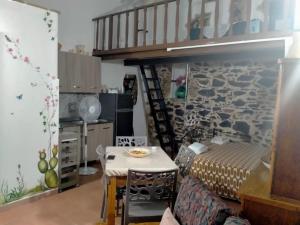 a room with a table and a kitchen with a staircase at La lammia di Pisticci in Pisticci