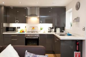 ノッティンガムにあるBowling Green Apartment - West Bridgfordのキッチン(黒いキャビネット、白いカウンタートップ付)