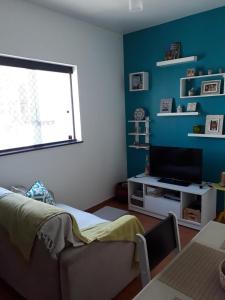 sala de estar con sofá y TV en Vista&Aconchego en Santos