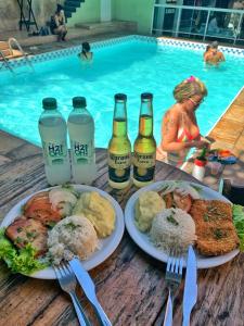 Maraca Hostel في ريو دي جانيرو: طاولة مع أطباق من الطعام وزجاجات من البيرة