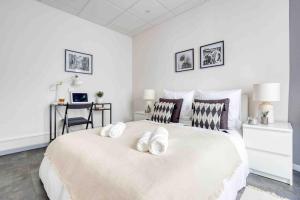 - une chambre blanche avec un grand lit blanc et 2 oreillers dans l'établissement Ô Paisible proche Paris Wifi Netflix Parking, à Saint-Ouen