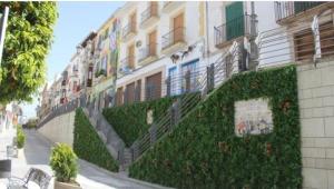 a building with ivy growing on the side of it at Apartamento La Muralla in Baena