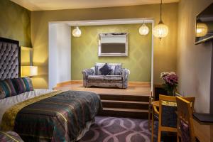 a bedroom with a bed and a chair in a room at Errigal Country House Hotel in Cootehill