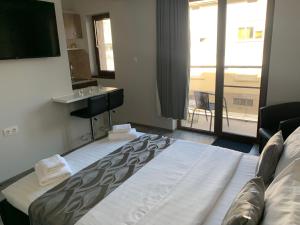 um quarto de hotel com uma cama grande e um lavatório em Vivian Apartaments em Sandanski