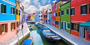 a group of boats in a canal with colorful buildings at Grengarden home in Mogliano Veneto