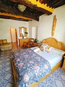 a bedroom with a large bed with a blue comforter at Castaño Real in Atalbéitar +36 photos