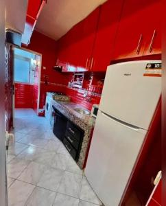 a kitchen with red walls and a white refrigerator at A lovely apartment with a nice view in Casablanca