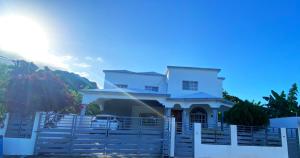 a white house with a white fence at Quiet Apartment, 3 Minutes From The Beach, 24H Security, Excellent Internet in San Felipe de Puerto Plata