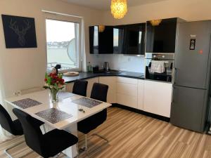 a kitchen with a table with chairs and a refrigerator at Apartament Wanessa in Gdańsk