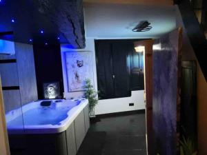 een grote badkamer met een groot bad met blauwe verlichting bij Loveroom La Parenthèse d ‘Auxerre in Auxerre