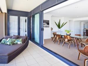 a living room with a couch and a dining room at Something Special 502 Sebel Kiama in Kiama +15 photos