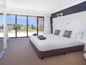 a bedroom with a large bed with a large window at Something Special 502 Sebel Kiama in Kiama