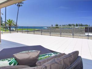a couch on a patio with a view of the beach at Something Special 502 Sebel Kiama in Kiama