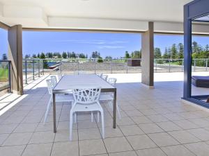 a white table and white chairs on a patio at Something Special 502 Sebel Kiama in Kiama