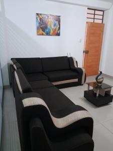 a living room with a black couch and a table at Cozy Whole Apartment in Lima