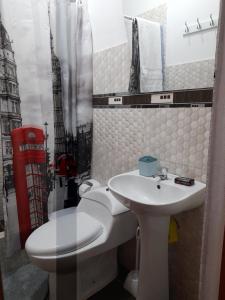 a bathroom with a toilet and a sink at Cozy Whole Apartment in Lima