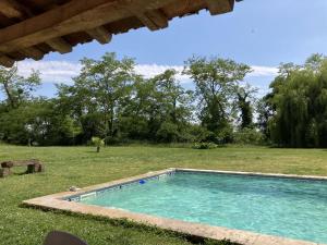 a swimming pool in a yard with a field at Domaine de la Grenadille 
