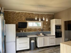 a kitchen with white cabinets and a white refrigerator at Domaine de la Grenadille 