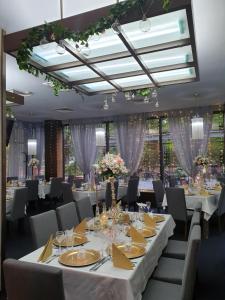 Hotel Presidivm Palace في لوفيتش: غرفة طعام مع طاولات وكراسي بيضاء