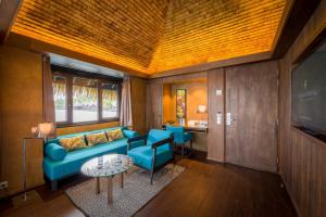 - un salon avec un canapé bleu et une table dans l'établissement InterContinental Tahiti Resort & Spa, an IHG Hotel, à Fa'a'ā