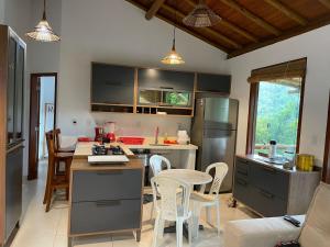 a kitchen with a table and chairs and a refrigerator at Dudu House em Villas de São José Itacaré in Itacaré