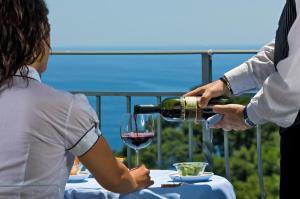 a man pouring a woman a glass of wine at Hotel La Floridiana in Capri