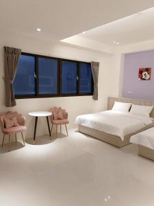 a bedroom with a bed and a table and chairs at Penghu Michi Homestay in Hsing-wen