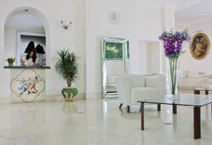 Biały salon ze stołem i kanapą w obiekcie Hotel La Floridiana w mieście Capri