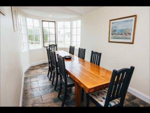 a dining room with a wooden table and chairs at Pooh Corner, Cottage in Robe