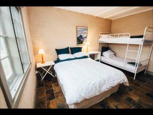 a bedroom with a bed and two bunk beds at Pooh Corner, Cottage in Robe