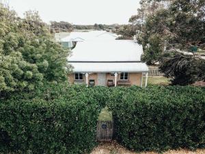 a house behind a hedge in front of a house at Pooh Corner, Cottage in Robe
